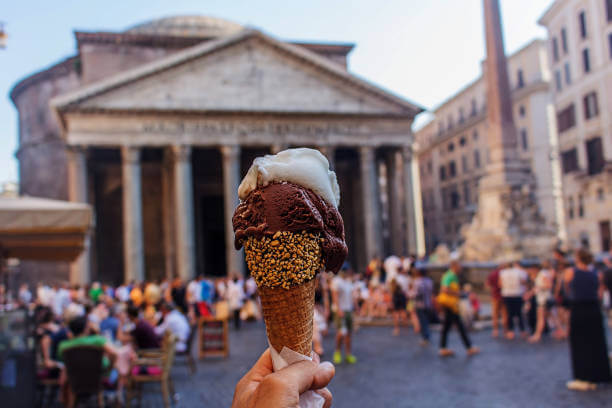 Family enjoying gelato while walking through illuminated Piazza Navona at night”