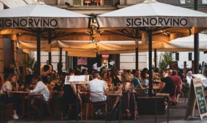 Outdoor dining tables and local restaurants at Piazza Santo Spirito Florence Italy