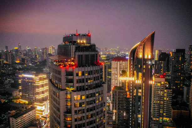 Night view of Sukhumvit Bangkok skyline with rooftop bars and BTS line.