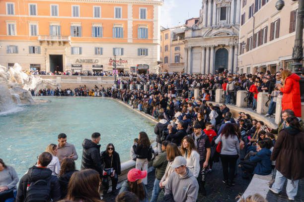 Visitors tossing coins into Trevi Fountain for good luck.