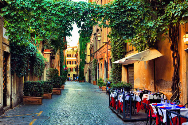 Charming alley in Trastevere with ivy-covered walls and lively trattoria tables