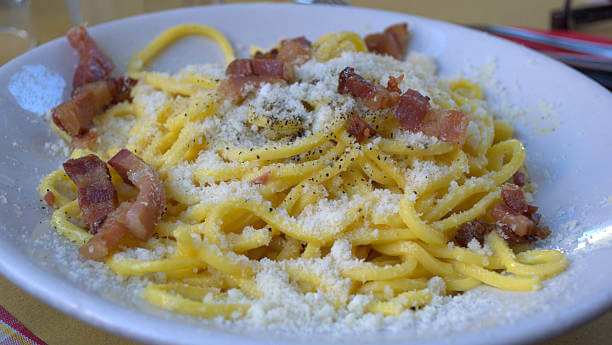 Classic Roman pasta dishes—Cacio e Pepe and Carbonara—served in a traditional trattoria.