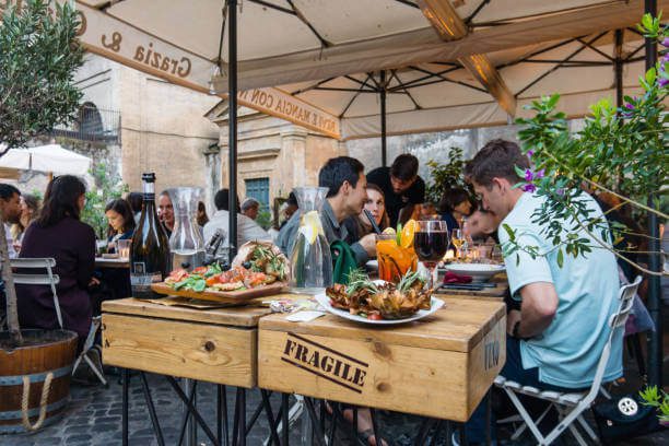 Warm and inviting Roman trattoria filled with locals enjoying traditional Italian dinner in the evening