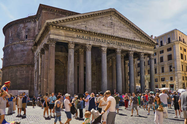 Pantheon exterior with large granite columns and visitors in Piazza della Rotonda.