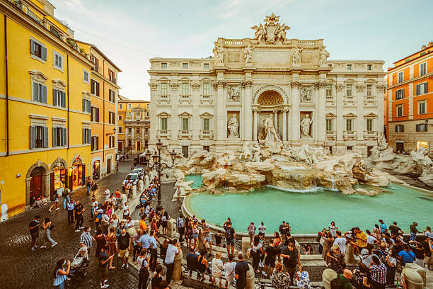 Trevi Fountain in Rome lit by soft morning light with tourists tossing coins