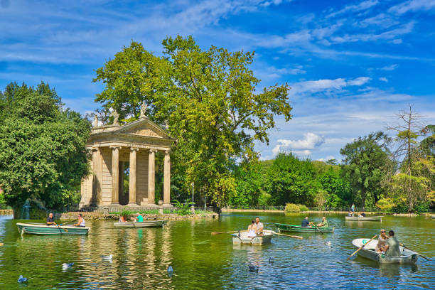 Visitors biking through Villa Borghese Gardens with scenic paths and greenery