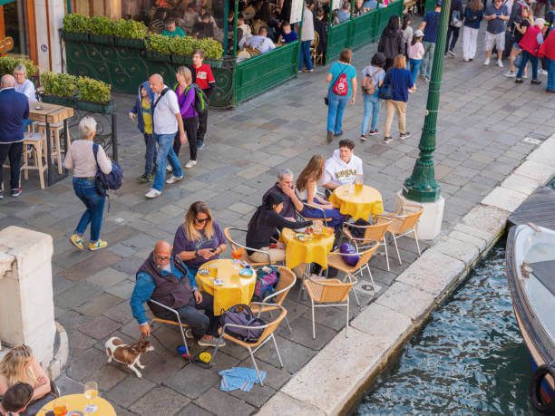 Locals relaxing in a quiet Venetian square near a canal.