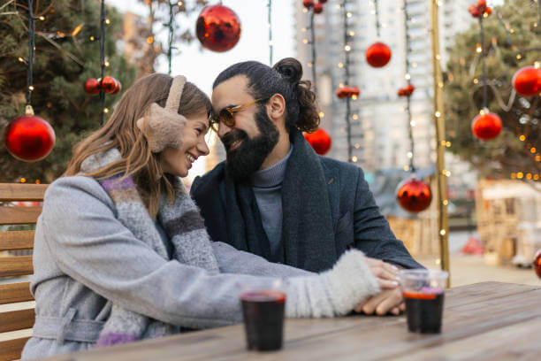 Couple sitting at an outdoor café near a Roman piazza during winter