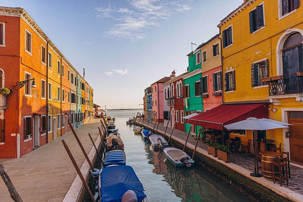 Colourful houses lining the canals of Burano island near Venice Italy on a sunny day