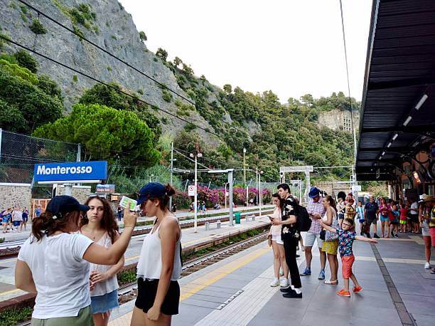 Tourists at Cinque Terre train station buying tickets to travel