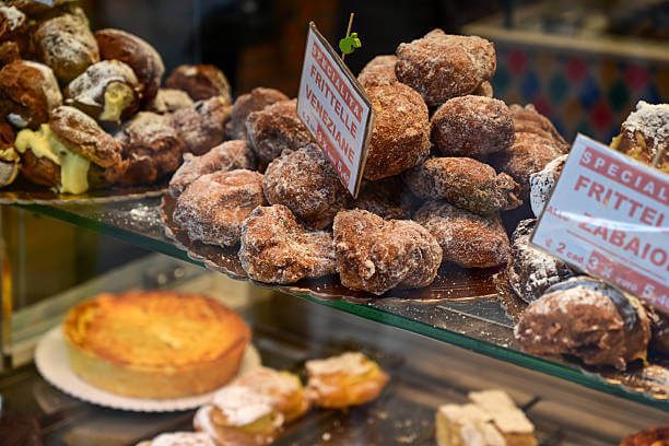Venice Italy traditional sweets baicoli biscuits, fritelle veneziane, and bussolai buranelli from Burano