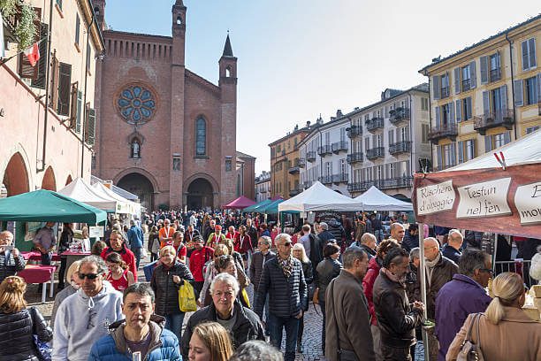 Festival in October truffle hunters displaying white truffles at the outdoor market in Alba