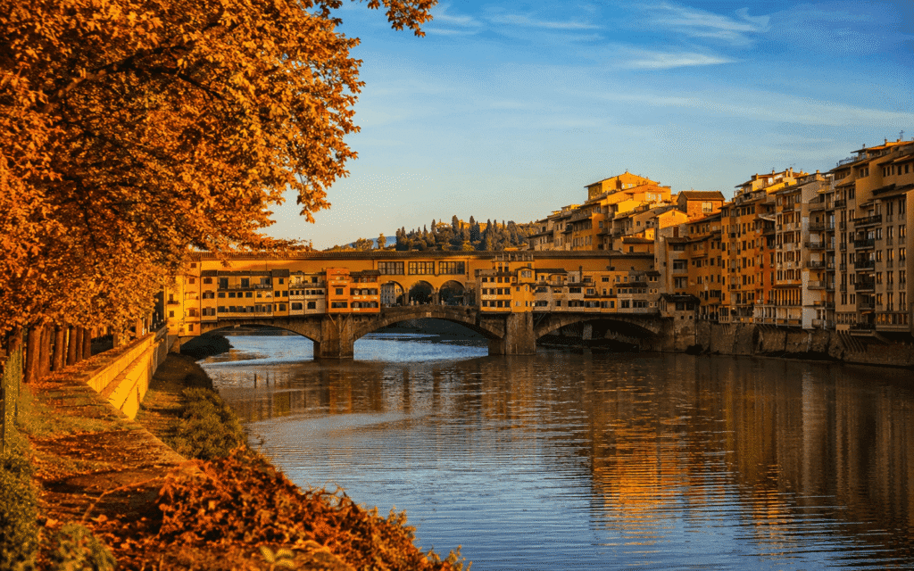 Florence Ponte Vecchio with amber leaves on the Arno riverbanks