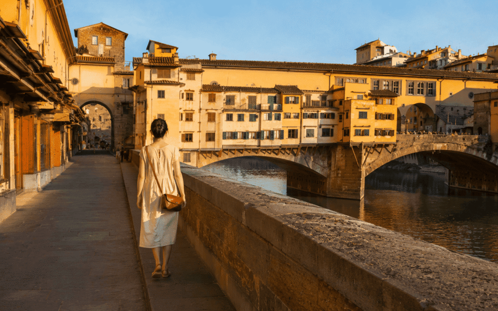 Florence safety for solo female travel solo woman crossing Ponte Vecchio in morning