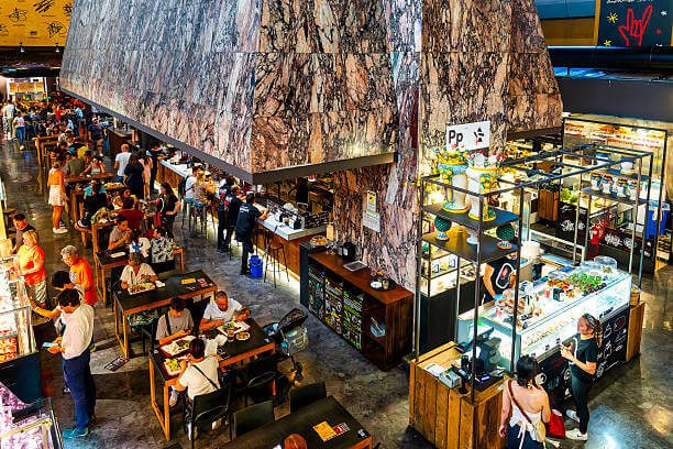 Solo dining at Mercato Centrale Florence solo traveller at a shared food hall table eating fresh pasta with a glass of wine
