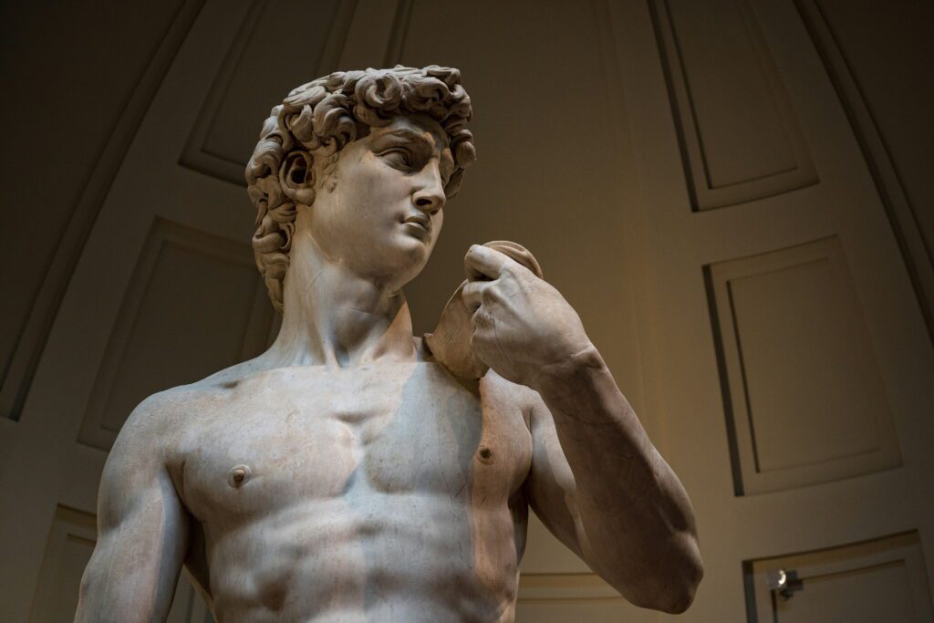 Things to do in Florence alone solo traveller standing before Michelangelo's David statue at the Accademia Gallery in Florence