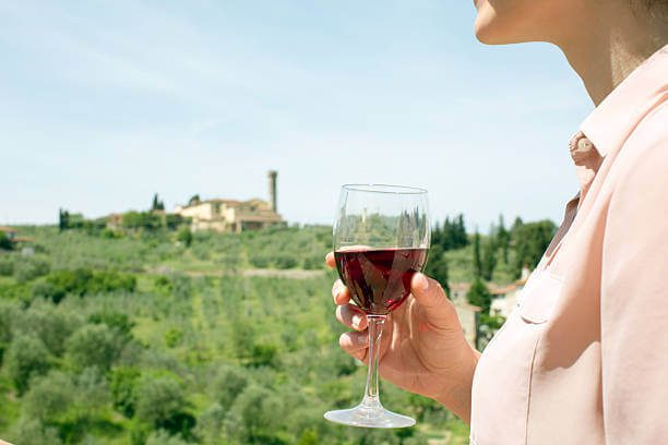 solo traveller at a wine bar counter with a glass of Chianti Classico