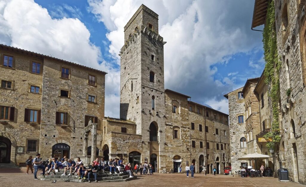 San Gimignano day trip from Florence solo medieval hilltop town with famous towers against blue sky and Tuscan countryside below