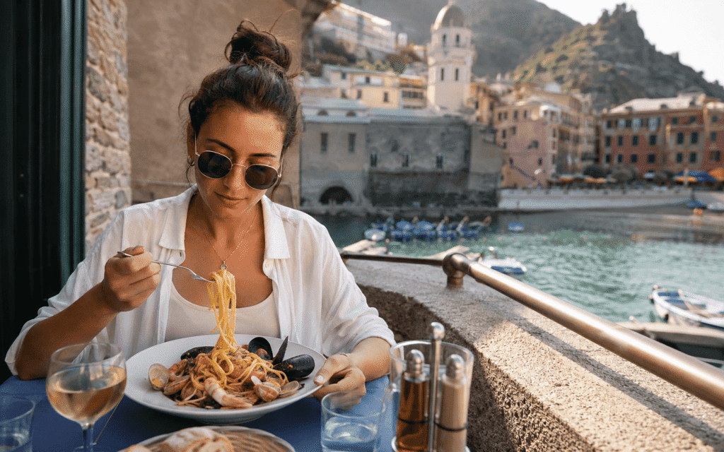 Solo dining in Cinque Terre solo traveler eating fresh seafood linguine at a small Vernazza restaurant