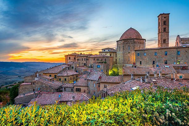 Volterra day trip from Florence solo dramatic Etruscan hilltop town with medieval towers against Tuscan countryside and moody sky