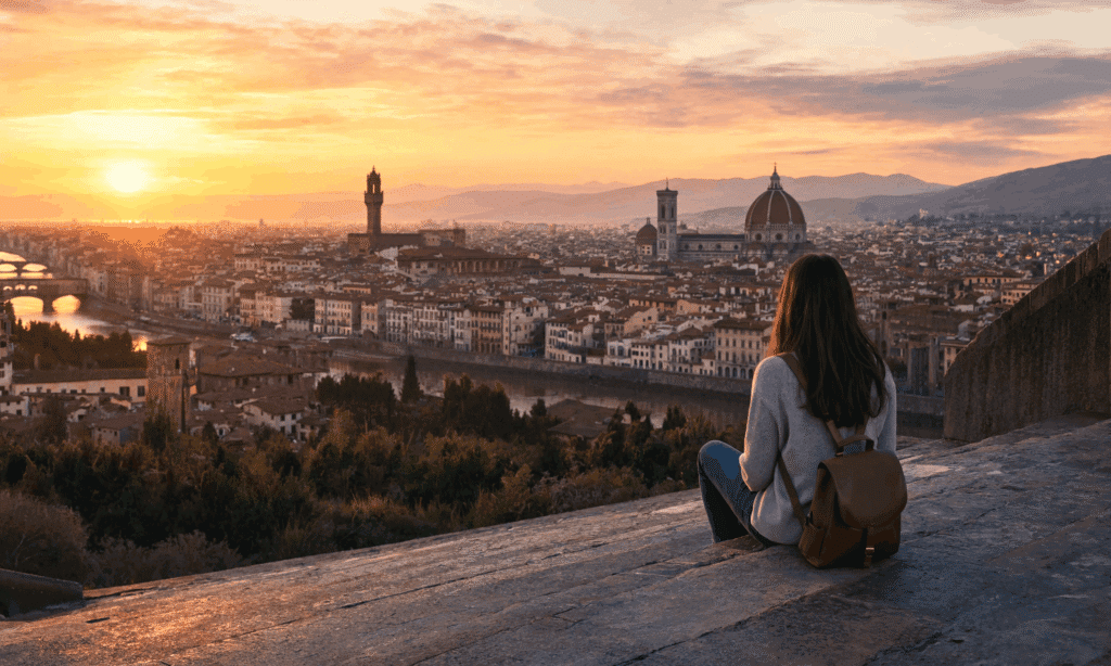 free solo activity in Florence solo traveler sitting alone on the Piazzale Michelangelo steps watching the golden sunset